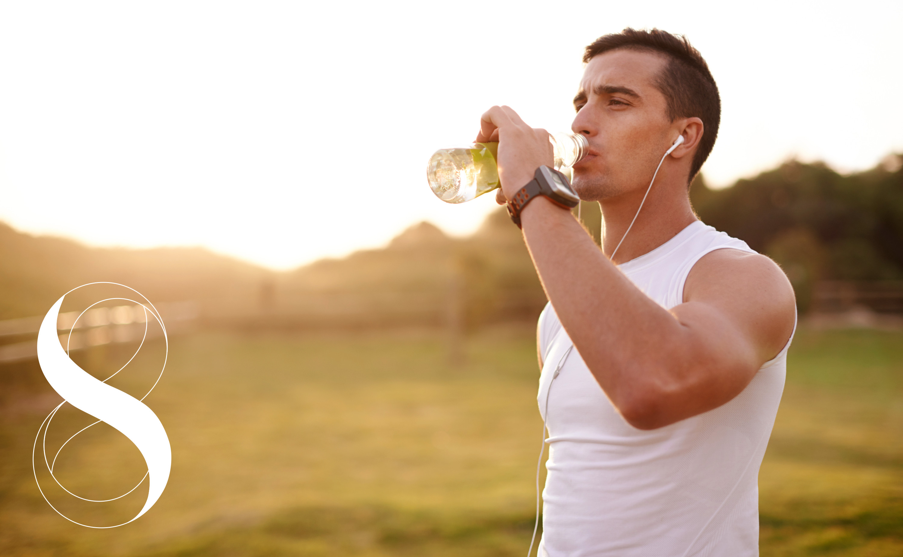 Ein sportlich gekleideter Mann beim Training an einem sonnigen Tag im Freien trinkt aus einer durchsichtigen Flasche und sorgt für ausreichende Hydration.