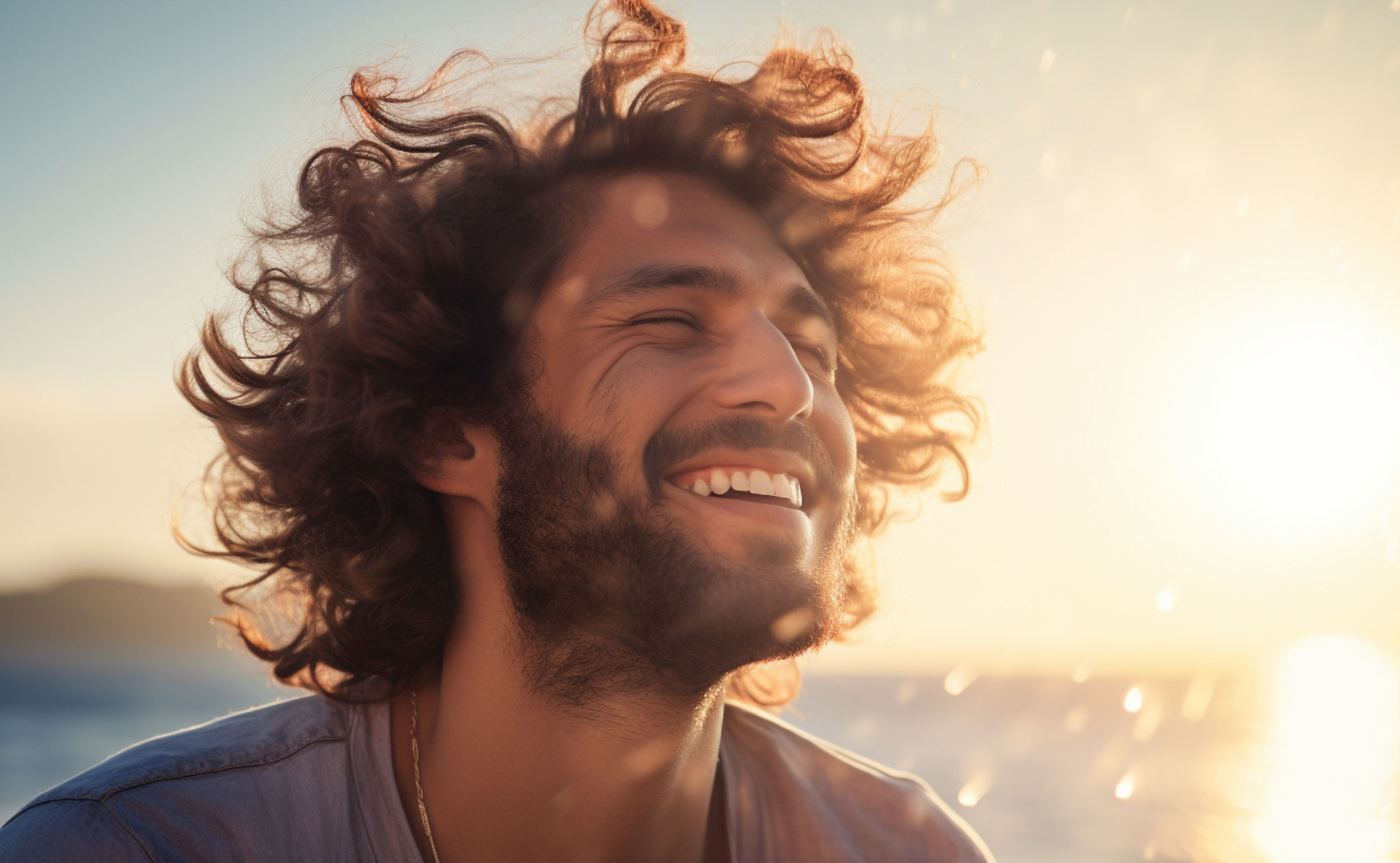 Ein lächelnder Mann im Sonnenaufgang am Meer, der die Augen geschlossen hat und das Sonnenlicht genießt symbolisiert mentale Gesundheit mithilfe der Natur.